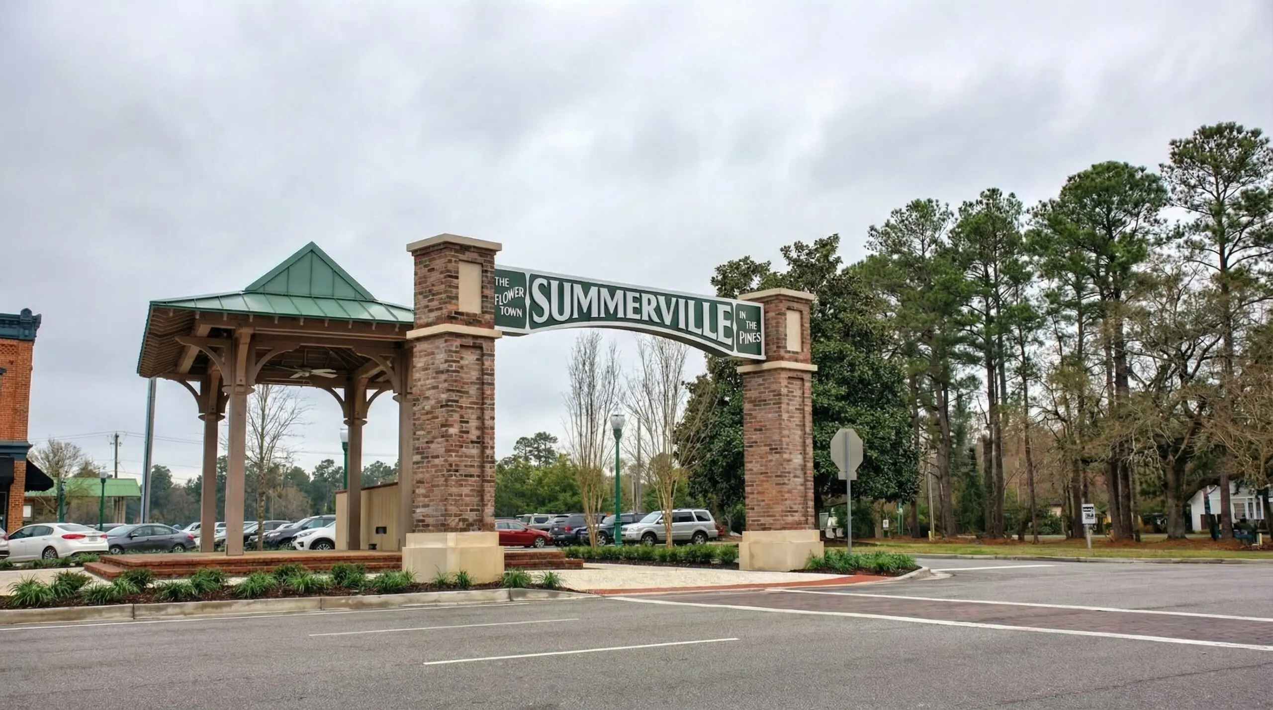 A large brick and metal entrance sign reading “SUMMERVILLE” stands beside a parking lot and trees on a cloudy day, marking the entrance to the town, where local Heating Repair services keep homes comfortable year-round.